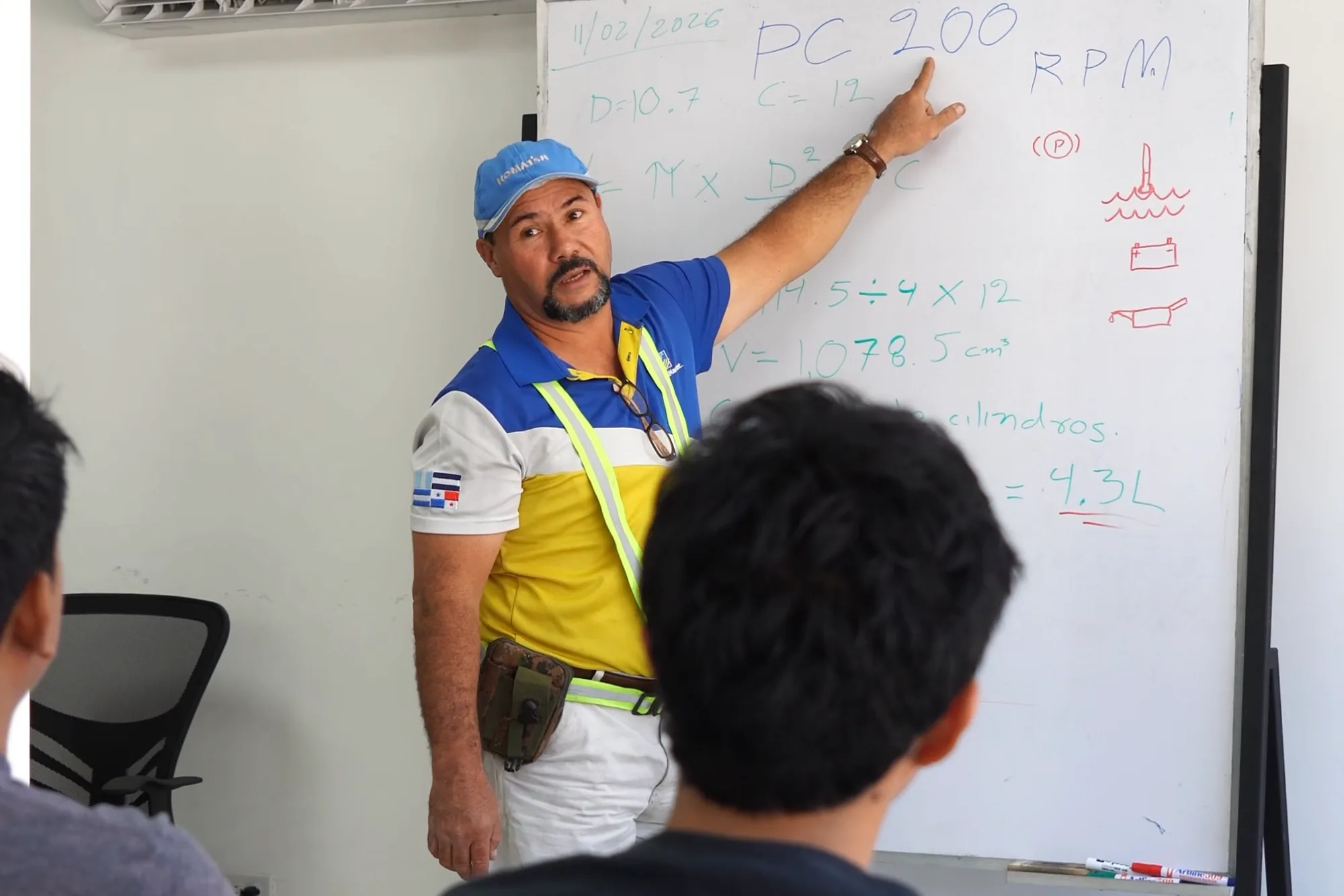 Instructor explaining at the whiteboard in the academy classroom in front of a group of trainees