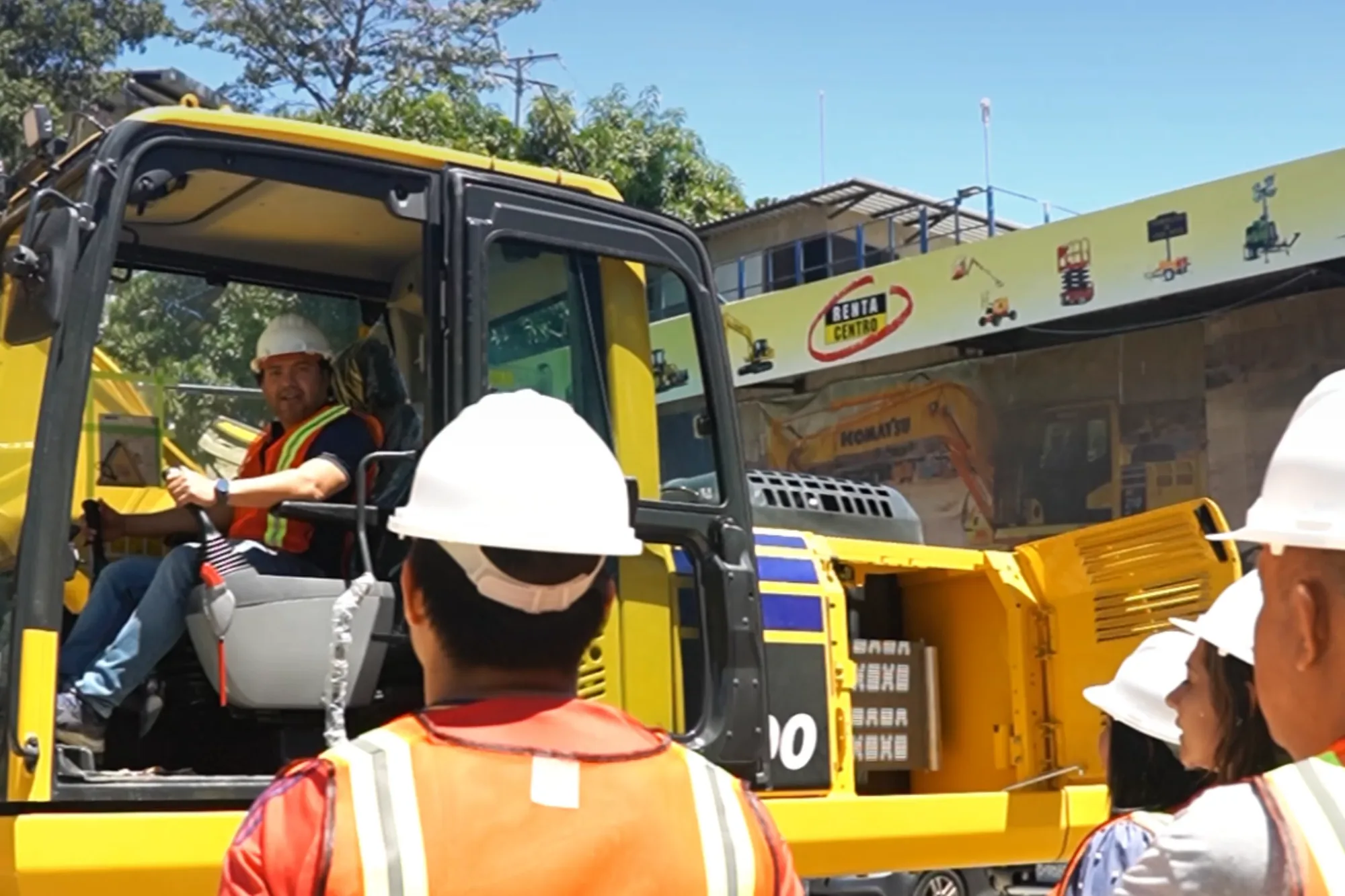 Crew in hard hats and vests in front of excavators during field practice
