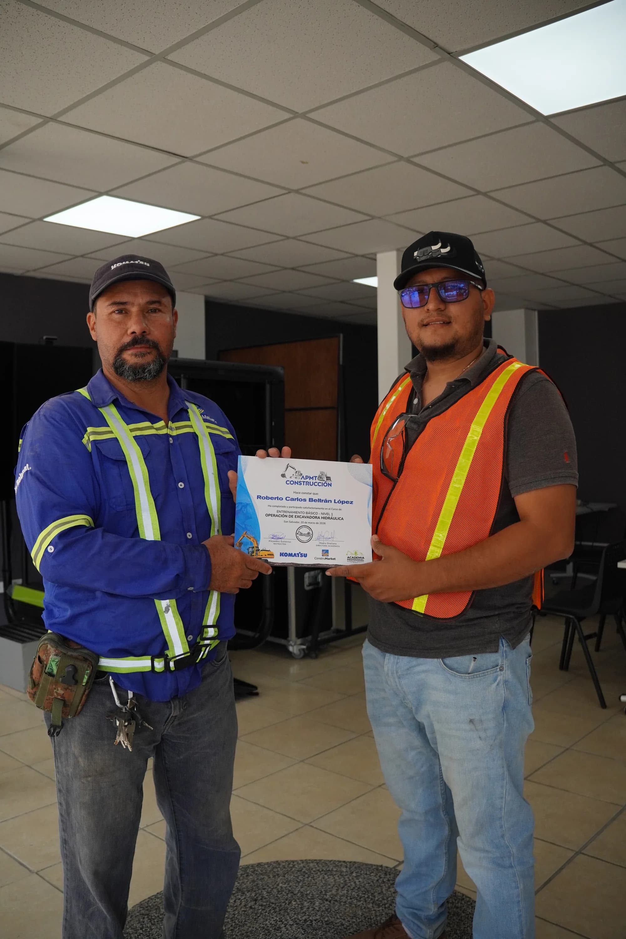 Graduate receiving a certificate from the instructor in the simulator room