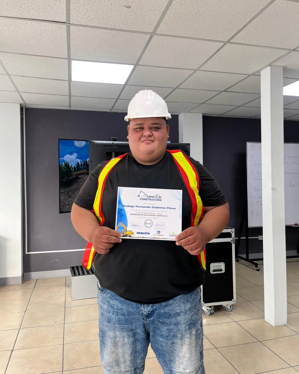 Rodrigo Fernando Gutiérrez Pérez con casco y su certificado en la sala de simuladores